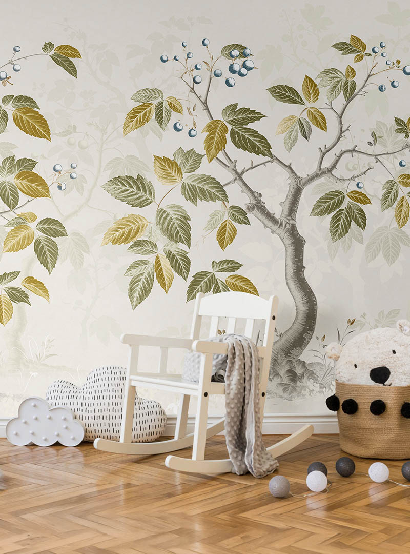 Skog II botanical wallpaper installed in a nursery with a white rocking chair, wooden flooring, soft toys, and neutral accessories.
